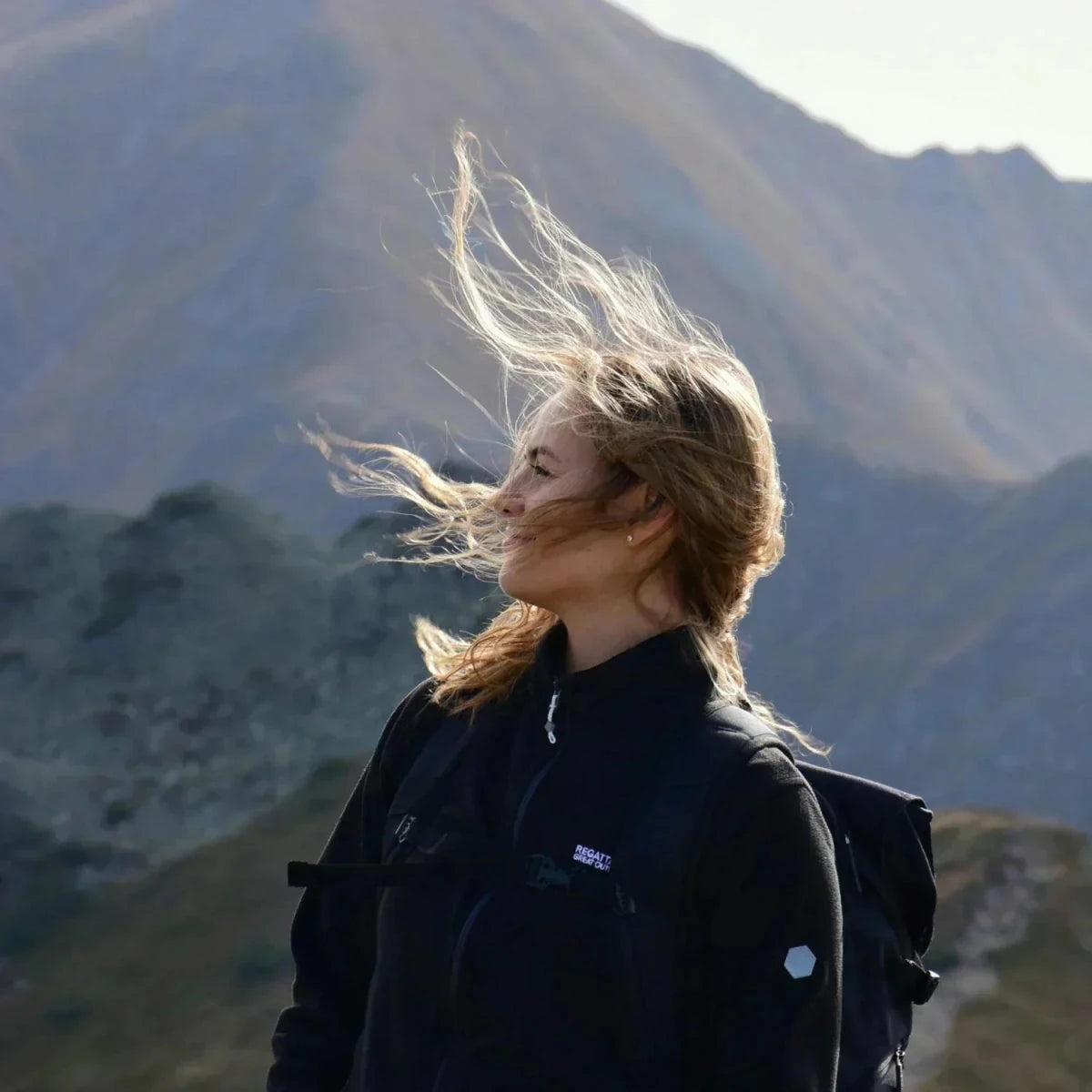 Bergsteigerin mit Wind im Gesicht